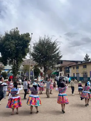 a group of children in colorful dresses playing with a kite at Posada El Pino