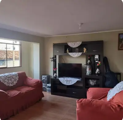 a living room with a couch and a flat screen tv at Habitación Los Solises in Jauja
