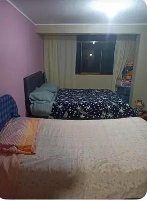 a bedroom with two beds and a window at Habitación Los Solises in Jauja