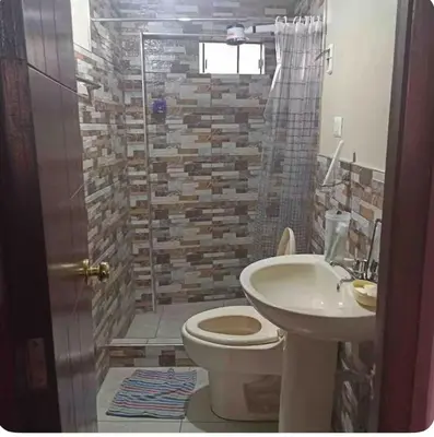 a bathroom with a toilet and a sink and a shower at Habitación Los Solises in Jauja