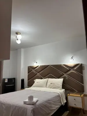 a bedroom with a large bed with a brown headboard at Hospedaje Ariana in Supe