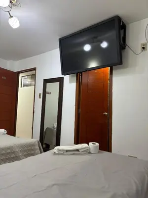 a room with a tv on the wall and a bed at Hospedaje Ariana in Supe