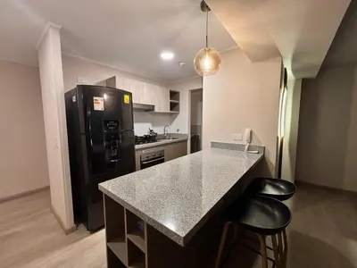 a kitchen with a black refrigerator and two bar stools at Apartment in Larco - Miraflores in Lima