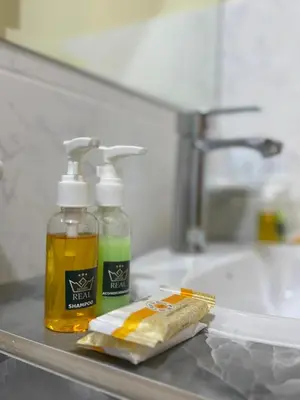 a bathroom sink with two bottles of soap and a toothbrush at Gran Hotel Real in Huancayo