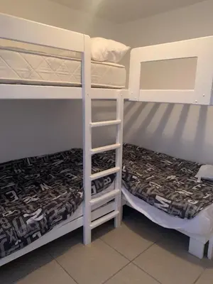 two bunk beds in a room with a bed at Beach House - Condominio Asia Bonita in Asia
