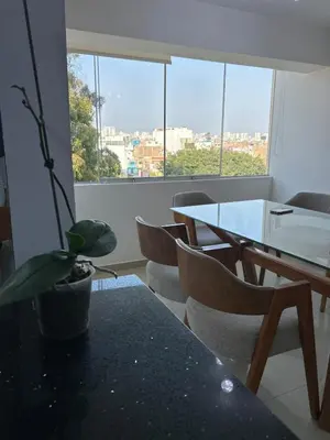 a room with a table and chairs and a large window at Spacious and bright apartment with a beautiful view in Lima