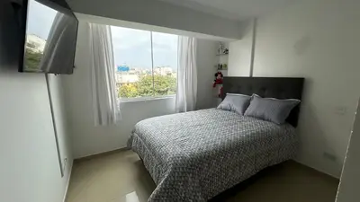 a small bedroom with a bed and a window at Spacious and bright apartment with a beautiful view in Lima