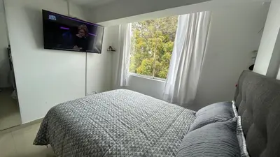 a bedroom with a bed and a tv on the wall at Spacious and bright apartment with a beautiful view in Lima
