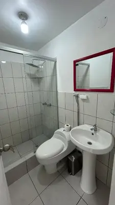 a bathroom with a white toilet and a sink at Spacious and bright apartment with a beautiful view in Lima