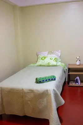 a bed with a pillow and a remote control on it at Posada del Carmen in Quillabamba