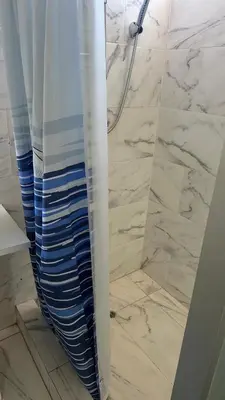 a bathroom with a shower with a shower curtain at Cozy room with kitchenette and private bathroom in Cusco