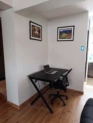 a black desk with a laptop on it in a room at Sumaq Sky in Cusco
