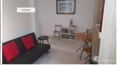 a living room with a black couch and a table at Tiki in San Bartolo