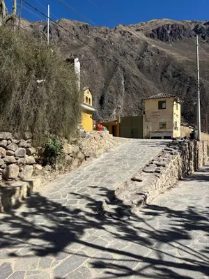 a road with a building on the side of a mountain at Lavanda lodge Ollantaytambo in Ollantaytambo