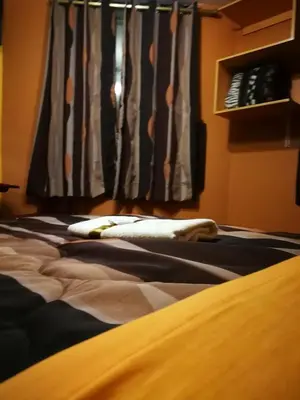 a bed with pillows on it in front of a window at Hostal GQ in Lima