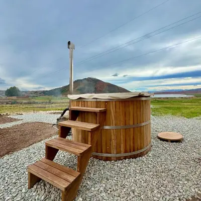 a wooden hot tub and steps in a field at Tiny House con Jacuzzi, Fogata y Starlink in Anta