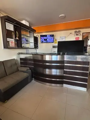 a bar in a restaurant with a couch and a counter at Hospedaje Don Luciano in San Vicente de Cañete