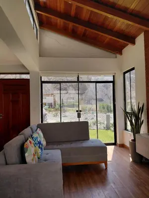 a living room with a couch and a large window at Casa de Campo en Santa Rosa de Quivez in Santa Rosa de Quives