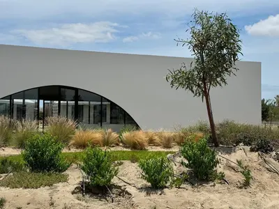 a building with a tree in front of it at Beautiful house with pool in Oasis Bahía de Paracas in Las Palmeras