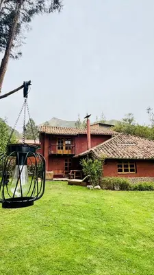 a house with a swing in front of a yard at Casa Munay in Urubamba