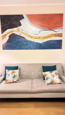 a couch with two pillows sitting under a painting at Apartment in Lima close to everything in Lima