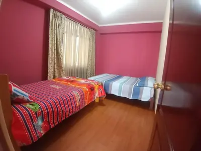 a bedroom with pink walls and a bed and a window at Casa Hospedaje Minidepa Piquichas in Abancay
