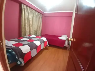 a small bedroom with a bed and pink walls at Casa Hospedaje Minidepa Piquichas in Abancay