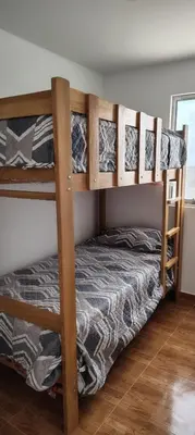 a bedroom with two bunk beds in a room at Casa en condominio en Paracas, a 7 min del Chaco in Puerto Nuevo