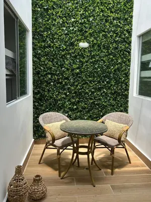 a table and chairs on a patio with a green wall at Casa de Playa en Puerto Viejo, Condominio Kalua in San Antonio