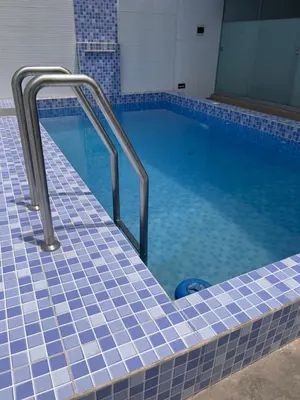 a swimming pool with blue tiled floors and blue tiles at Departamento 201 in Punta Negra