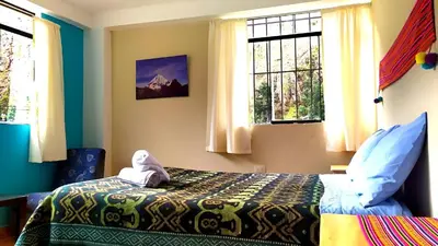 a bedroom with a bed with a stuffed animal on it at Lycka Wasi Hospedaje in Ollantaytambo