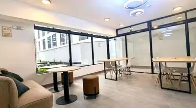 a room with tables and a couch and some windows at Vital Building - Modern Apartment Miraflores in Lima