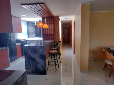 a kitchen with a counter and stools in a room at Casa Quevedo in Ica