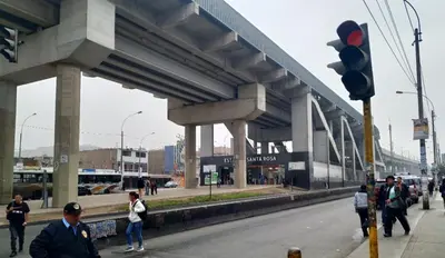 a group of people walking on the street under a bridge at Habitación equipada en san juan de Lurigancho in Lima