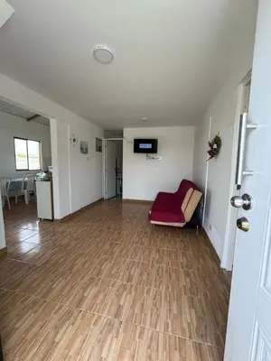 an empty living room with a red couch and wooden floors at Amplia casa petfriendly con parrilla cerca a Asia in Salitre