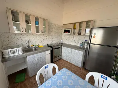 a kitchen with a refrigerator and a table and chairs at Amplia casa petfriendly con parrilla cerca a Asia in Salitre