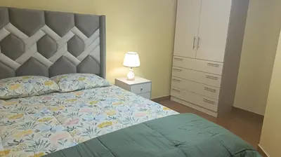 a bedroom with a bed and a dresser and a lamp at Boulevard home hostel - Lima Airport in Lima