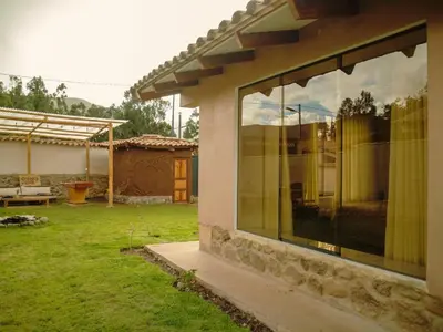 a house with large glass windows in a yard at Mountain retreat with private sauna in Urubamba in Urubamba