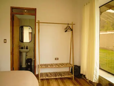 a bedroom with a bed and a sink and a window at Mountain retreat with private sauna in Urubamba in Urubamba
