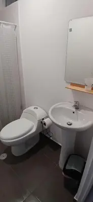 a bathroom with a white toilet and a sink at Condominio Vive Paracas in Puerto Nuevo