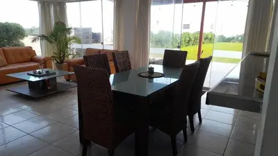 a dining room table and chairs in a living room at Casa Frente al mar en club privado in Lurín