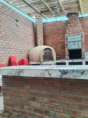 a brick oven with red chairs and a brick wall at Finca Lucía Kemper in San Vicente de Cañete