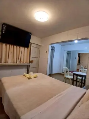 a bedroom with a bed and a flat screen tv at Princess Hotel in Supe