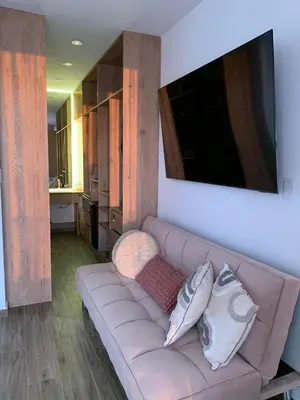 a living room with a brown couch with pillows at Topará Beach House in San Vicente de Cañete