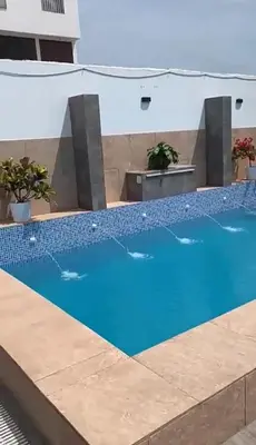 a large swimming pool with blue water in a building at Casa pulpos in Punta Hermosa
