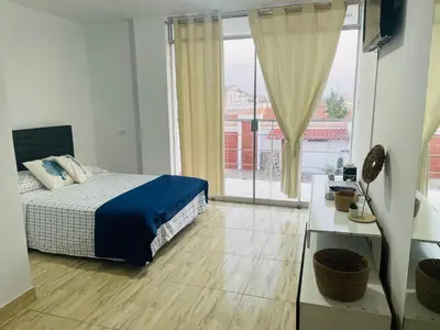 a bedroom with a bed and a large window at Casa pulpos in Punta Hermosa