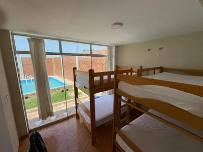 a room with two bunk beds and a large window at Casita de Playa 2026 in Supe