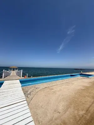a swimming pool on the beach next to the ocean at Oceanfront apartment con opcion de Velero in Paracas