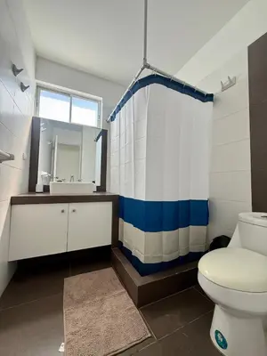 a bathroom with a toilet and a sink and a mirror at Oceanfront apartment con opcion de Velero in Paracas