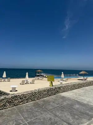 a beach with chairs and tables and the ocean at Oceanfront apartment con opcion de Velero in Paracas